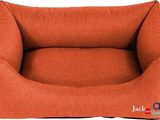 un panier pour chien orange avec un grand coussin dessus