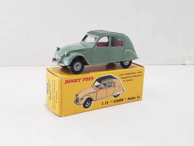 a green toy car sitting on top of a yellow box