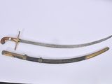 two swords on a white surface with a gold handle