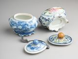 three pieces of blue and white porcelain teapots and saucers on a table