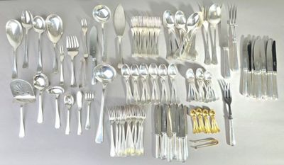 a lot of silver spoons and forks hanging on the wall
