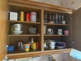 de nombreuses tasses et mugs sur les étagères de la cuisine