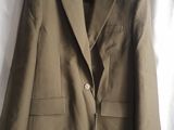 the jacket is hanging on a hanger next to a white curtain