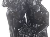 statue of two women sitting on a rock with a basket of grapes