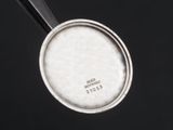 a silver spoon with a black handle on a black surface