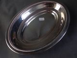 a silver plate on a table with a black background