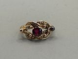 an image of a gold ring with a red stone in the middle