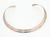 gros plan d'un bracelet en argent sur une surface blanche