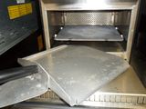 a metal pan sitting inside of an oven with a spatula in it