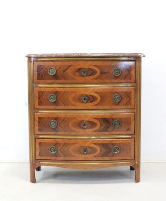 an antique chest of drawers with a marble top