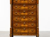 une commode ancienne ornée d'un motif floral sur la façade