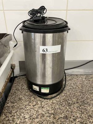 a large metal pot sitting on a counter next to a metal container