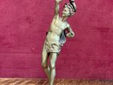 une statue en bronze d'un homme avec un chapeau sur la tête