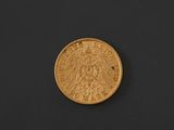 a gold coin on a black surface