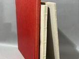 deux livres rouges empilés l'un sur l'autre sur une surface blanche