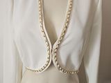 an image of a mannequin wearing a white top with pearls on it