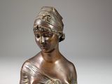 bronze statue of a woman holding a cat in her hands