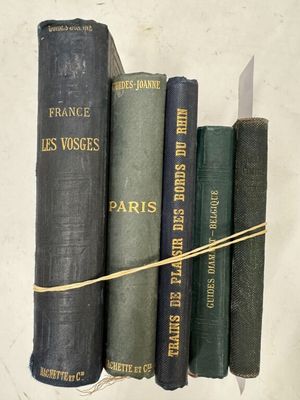 Plusieurs vieux livres sont alignés sur une étagère, attachés les uns aux autres
