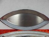 a silver plate with a fish on it next to a silver plate with a fish on it