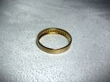a gold ring that is on a white surface