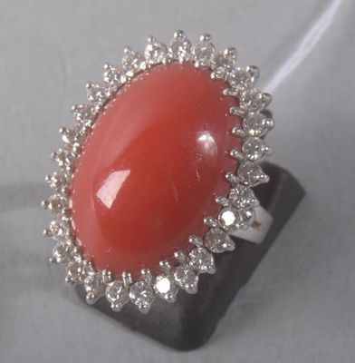 an image of a ring with a red stone surrounded by white diamonds