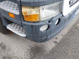 a close up of the front of a truck with its lights on