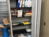 a metal storage cabinet with lots of supplies on top of it