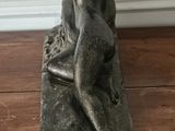 a statue of a woman sitting on top of a wooden box