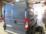 a van that is parked in a garage with a lot of bikes in the background