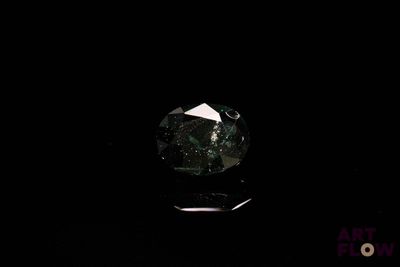 gros plan d'un diamant vert sur une surface noire