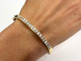 a close up of a woman ' s hand wearing a gold bracelet with diamonds