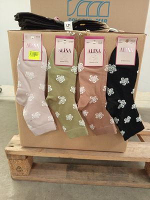 three pairs of women ' s socks are on a pallet in front of a box