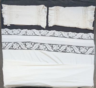 a white bed with a black and white comforter and pillows