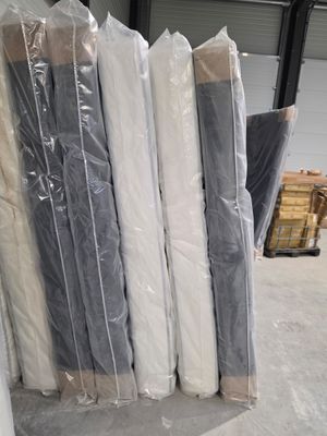 de nombreux rouleaux de matelas posés à même le sol dans un entrepôt