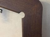 a picture of a wooden shelf with hooks on it