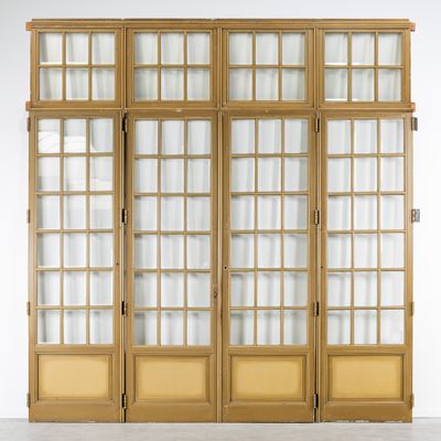 a tall wooden cabinet with glass doors and a rug on the floor