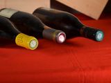 three bottles of wine sitting on a red table