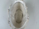 a silver vase with a gold handle on a table