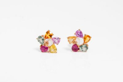 un gros plan sur une paire de boucles d'oreilles colorées posées sur une surface blanche