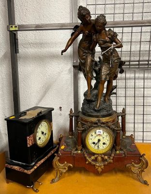 une statue représentant un garçon et une horloge posée sur une table