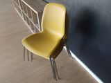 a yellow chair sitting in front of a black wall
