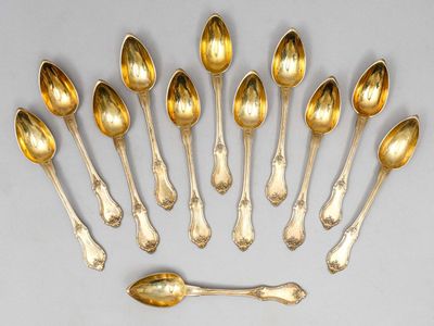 six cuillères et un repose-cuillère disposés en cercle sur une table