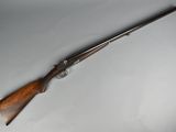 a rifle with a wooden handle on a white surface