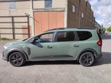 a small green car parked in front of a building