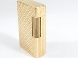 un briquet doré posé sur une surface blanche