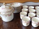 many cups and a teapot sitting on a table