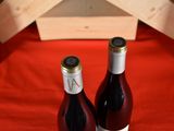 two bottles of wine sitting next to each other on a table