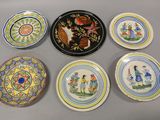 Plusieurs assiettes ornées de motifs sont posées sur une table