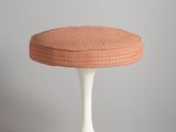 a white pedestal with a pink cushion on top of it