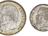 a silver coin with the head of a man in profile and the head of a woman in profile